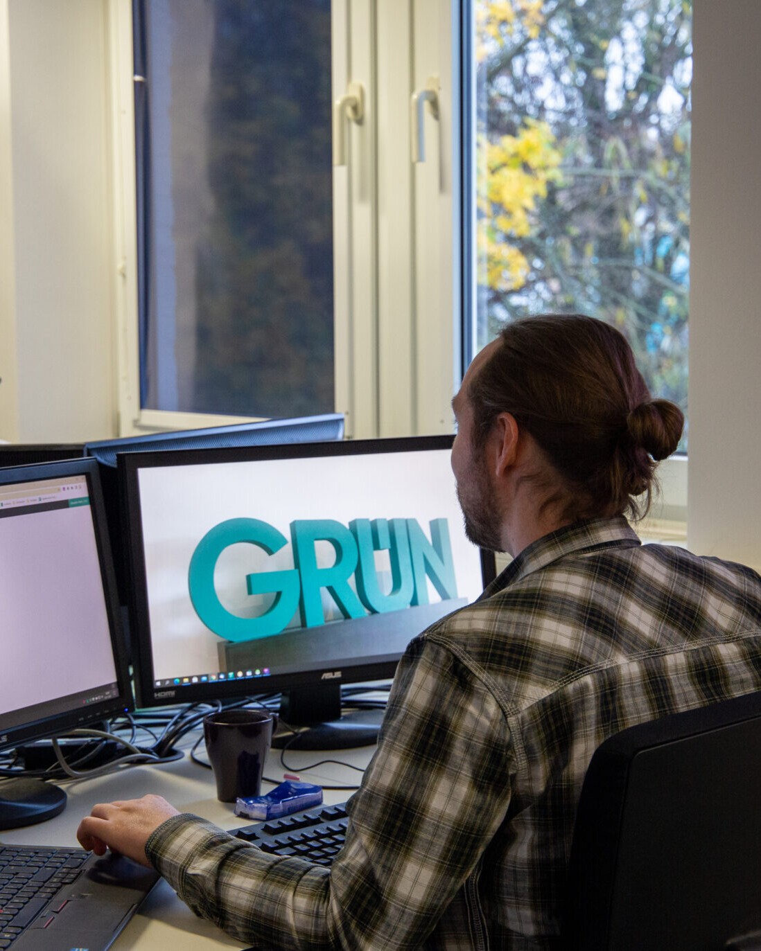 Software Support Mitarbeiter am Arbeitsplatz mit mehreren Monitoren